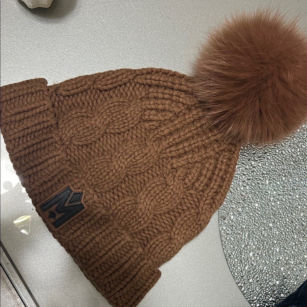 Mackage Nina beanie in the camel color with a natural fur pom